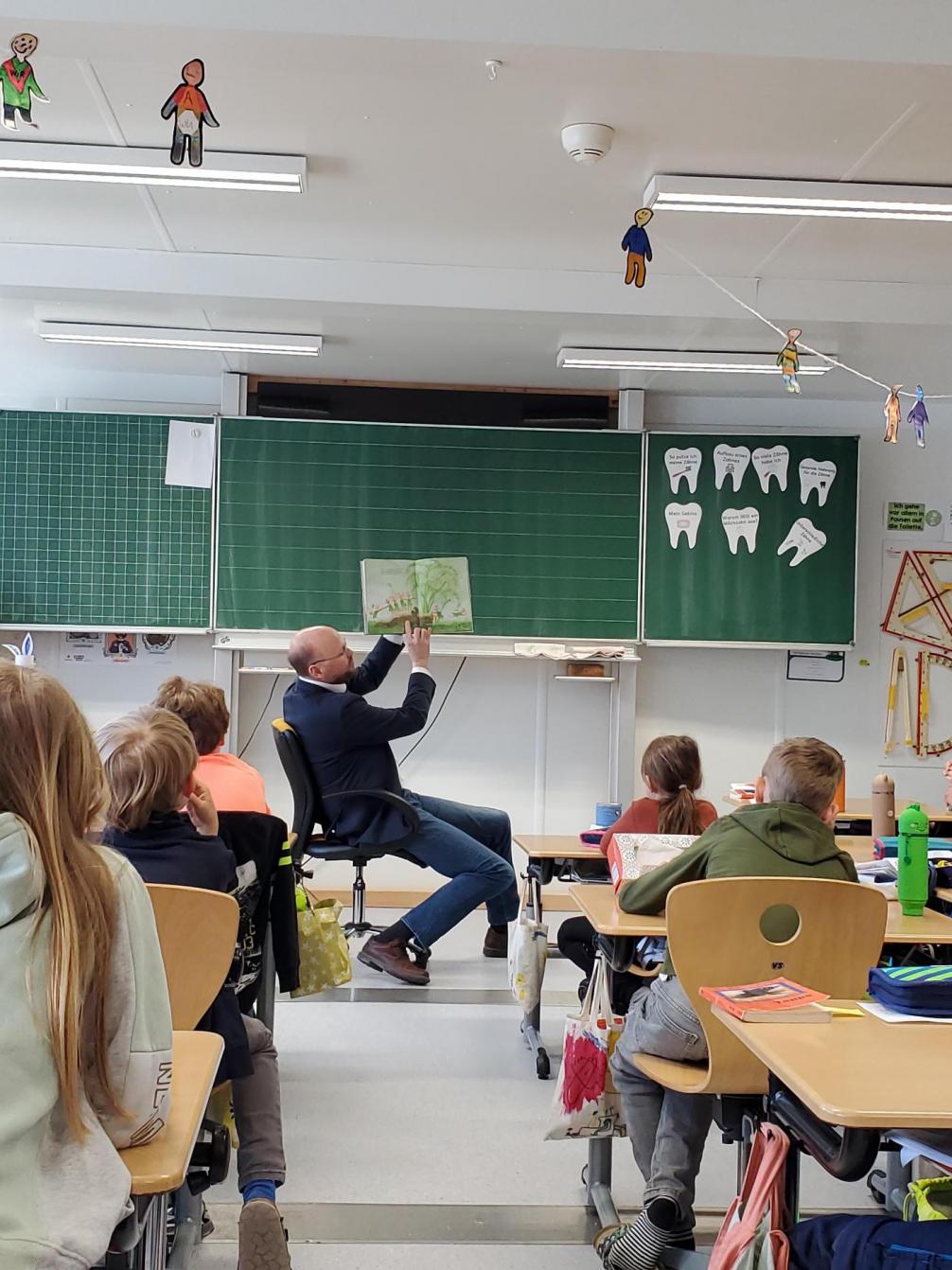Der Bürgermeister liest am Vorlesetag der 3.Klasse eine Geschichte vor und zeigt die Bilder dazu.